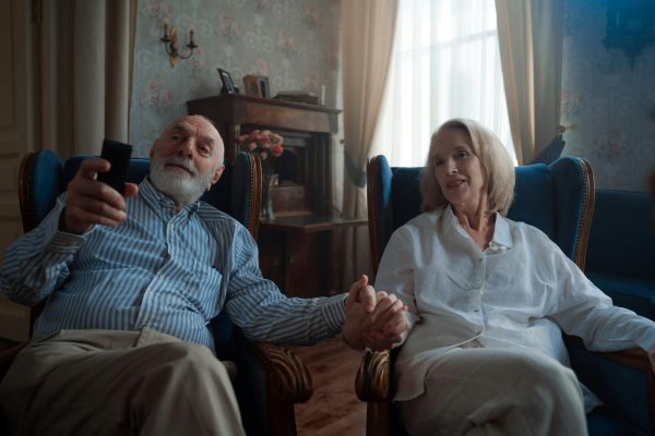 Older couple sitting together holding hands